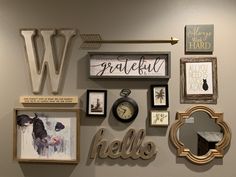 the wall is covered with many different types of framed pictures and decorative letters on it