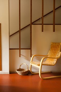 a wooden chair sitting next to a basket on the floor