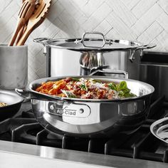 pots and pans are sitting on the stove top with utensils in front of them