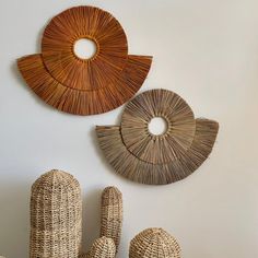 three wicker sculptures are hanging on the wall next to two cactus statues and one is shaped like a fish