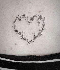 a heart shaped flower tattoo on the stomach