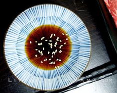 a blue and white plate topped with lots of small pieces of food on top of a table