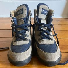 a pair of blue and grey sneakers on a wooden floor