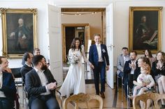 a bride and groom walking down the aisle to their wedding ceremony in front of an audience