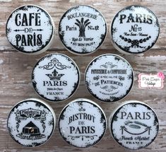 six white and black paris buttons with pink star on the top, in front of a wooden background