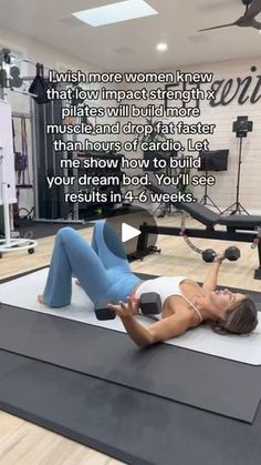 a woman laying on top of a mat in a gym