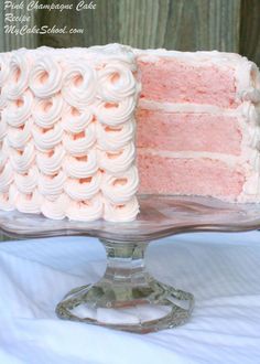 a pink cake with white frosting on a glass plate