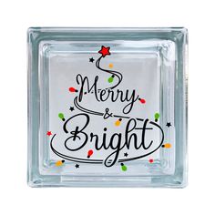 a glass block with merry and bright written on it