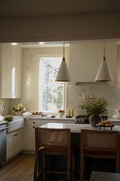 the kitchen is clean and ready to be used for cooking or baking, with two pendant lights hanging over the island