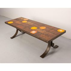 a wooden table with orange and yellow lights on it's top, against a white wall