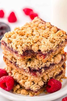 raspberry oatmeal bars stacked on top of each other with fresh raspberries