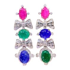 A multicolored pair of earrings, in sophisticated design, so fashionable and particular design, very adorable style. Earrings come in 18K with 2 pieces of Natural Zambian Emeralds , in perfect oval /cabochon cut of 22,00 carats, fine quality, stunning color , 2 pieces of Natural Tanzanites , in ideal oval/cabochon cut of 28,50 carats, fine quality, 2 pieces of Natural Burma Rubies in perfect oval /cabochon cut of 11,22 carats, fine quality, and 186 pieces of Natural Diamonds in round brilliant cut of 6,76 carats, F color VS clarity, so sparkly. Handcrafted by artisan goldsmith. Excellent manufacture and quality of stones . Complete with AIG report. Whosale price. Note: on my shipment, no taxes. Adorable Style, 18k Gold Earrings, Zambian Emerald, Zambia, Style Earrings, Oval Cabochon, Chandelier Earrings, Tanzania, Round Brilliant