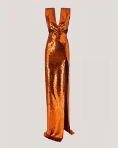 an orange sequinned dress with a long slit on the side and a bow at the back