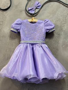 Gorgeous purple organza cocktail dress with removable belt  and hair bow. Top and bows are decorated with AB crystals. Cuffs and belt are  decorated with gems.  Zipper  back.   Color: purple, lilac, lavender. Can  be made special for your little girl in any size and color. Elegant Purple Pageant Dress, Fitted Purple Pageant Dress For Dress-up, Elegant Purple Princess Dress For Pageant, Elegant Purple Princess Dress For Pageants, Purple Embellished Pageant Dress, Purple Embellished Dress For Pageant, Embellished Organza Princess Dress For Party, Elegant Organza Princess Dress For Fancy Dress, Elegant Lavender Princess Dress For Party