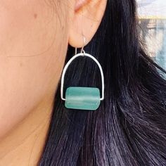 Say goodbye to generic jewelry and hello to something special! Our Magic Green Earrings are made from 925 Sterling silver, and a rectangle Recycled glass in green aqua color, making them earth-friendly and delightfully eye-catching. With these lightweight earrings in your collection, you'll be living your cool life – and lookin' good doin' it! 2 inches length. All jewelry is handmade to order in our Port Richey, Fl studio by owner and designer, Soledad. Please allow me 1-3 business days to make and package your piece(s). Your items are expected to be delivered within 7-10 business days after the items have been shipped and picked up by the delivery carrier. If you need your order fast, please email to solescott.jewelry@gmail.com If you have any questions, never ever hesitate to contact us. Green Sea Glass Earrings For Gift, Green Rectangular Earrings As A Gift, Rectangular Green Earrings Gift, Everyday Green Sterling Silver Earrings, Aqua Color, Earth Friendly, Green Earrings, Aqua Green, Light Weight Earrings