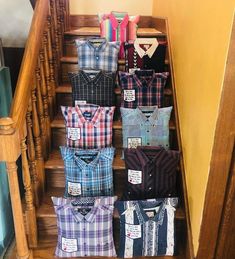 there are many different shirts on the stairs