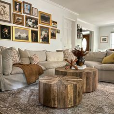 a living room with couches, tables and pictures on the wall above them in various frames