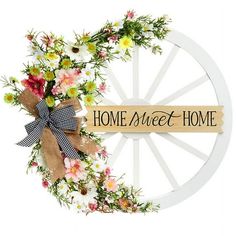 a wooden wheel with flowers on it that says home sweet home