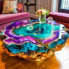 a table that is on top of a wooden floor in front of a purple couch