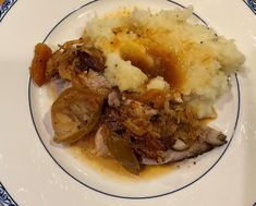 a white plate topped with mashed potatoes and meat