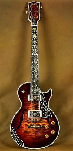 an intricately designed guitar is displayed against a brown background with gold accents on the neck and sides