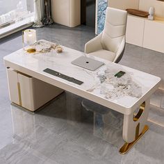 an office desk with marble top and gold trimmings in the middle of a room