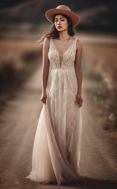 a woman in a dress and hat standing on a dirt road