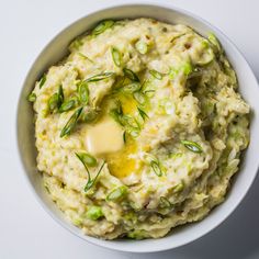 a white bowl filled with mashed potatoes topped with butter and sprinkles