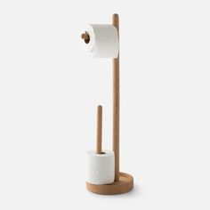 a toilet paper holder with two rolls of toilet paper on it and a wooden stick sticking out of the roll