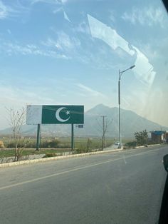 a road with a sign on the side of it and mountains in the back ground