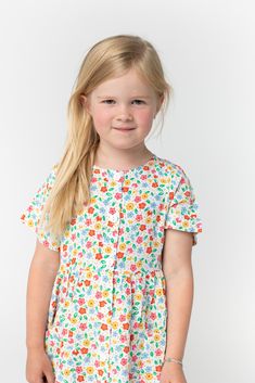 Girl's woven floral print, button down dress Short sleeves Front patch pockets Fabric content - Rayon - Dry clean only recommended Spring Printed Button-up Dresses, Playful Floral Print Dress For Garden Party, Cotton Floral Print Button-up Shirt Dress, Floral Print Cotton Button-up Shirt Dress, Multicolor Printed Button-up Dress, Casual Cotton Patterned Dresses, Cotton Button-up Shirt Dress With Floral Print, Casual Cotton Dress With Floral Print, Playful Spring Printed Dress