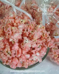 pink and white popcorn is in a glass bowl