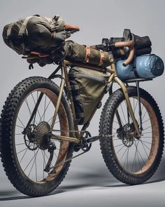 a man laying on top of a bike next to a sleeping bag and another person