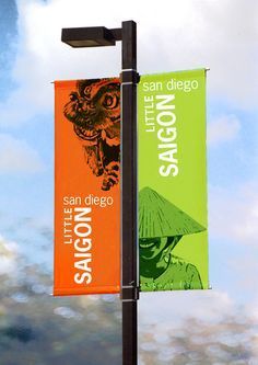 an orange and green banner hanging from a lamp post