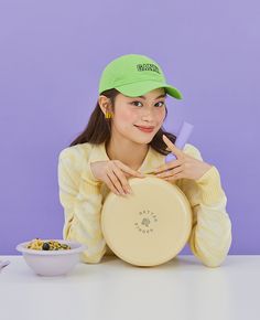 a woman sitting at a table with a frisbee in front of her