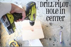 the drill pilot hole in center is being held by a person using a power tool