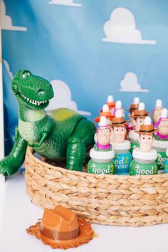 there is a basket full of toothpaste and some toy dinosaurs in the background