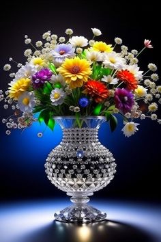 a vase filled with lots of colorful flowers on top of a blue table next to a black background