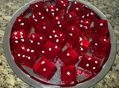 a bowl filled with red dices on top of a counter