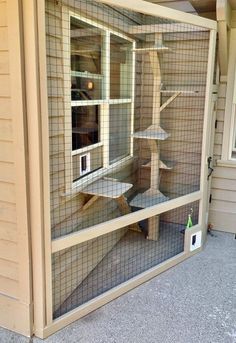 a large bird cage sitting on the side of a house