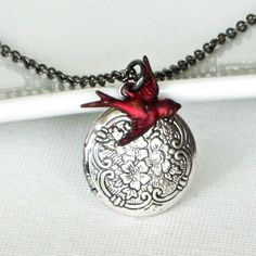 Bird Locket Necklace - Bright Red Bird accents a Small Antiqued Silver Locket with a Floral Design. The Locket is 20 mm (slightly smaller than US nickel) and has a floral pattern. Stainless Steel Chain This is a stock photo. Since the birds are hand finished, there are slight variations. For other bird locket designs: http://www.etsy.com/shop/mcstoneworks/search?search_query=bird+locket&order=date_desc&view_type=gallery&ref=shop_search For other locket designs: http://www.etsy.com/sh Red Locket Necklace For Wedding, Red Vintage Charm Necklace For Gift, Red Necklace With Vintage Charm For Gift, Red Necklace With Vintage Charm As A Gift, Personalized Vintage Red Jewelry, Bird Locket, Locket Necklace Silver, Locket Design, Silver Locket Necklace