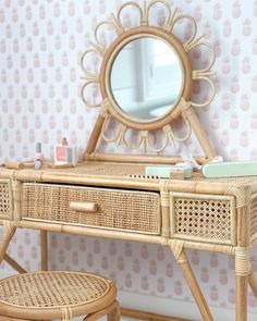 a wicker desk with a mirror and stool