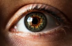 an extreme close up shot of a person's eye with brown and yellow iris