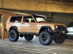 a jeep parked in a parking garage next to another car