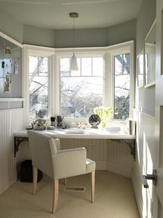 a chair sitting in front of a window next to a desk