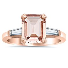 The emerald cut is a gemstone shape that typically comes with a wonderful sense of sophistication and grace, as seen in this 3 stone morganite engagement ring. Coupled with the sweet color of peachy pink morganite, the romantic sentiments of morganite and rose gold are taken to new levels of refinement with an emerald cut morganite stone. Set into a three stone engagement ring style band, the 2.50 ct center stone is flanked on either side by tapered baguette diamonds which highlight and accentuate the natural graceful beauty of the center morganite. For those who want a look that pops with the pink color of the gemstone more, we also offer white metal options for this emerald cut morganite engagement ring with baguettes.
Product Information
Metal: 14kt Gold, 18kt Gold, or Platinum
Finish: Peach Morganite Ring, Gold Bar Earrings Studs, Diamond Three Stone Ring, Baguette Engagement Ring, Stackable Wedding Bands, Engagement Ring Rose Gold, Three Stone Engagement Ring, Morganite Diamond, Emerald Engagement Ring Cut