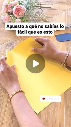 a woman is cutting paper on top of a table