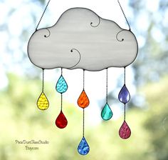 a wind chime with raindrops hanging from it's sides and a cloud in the background