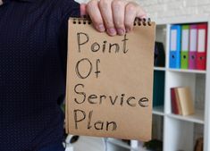 a person holding a piece of paper with the words point of service plan written on it