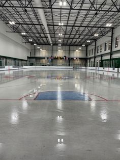 an empty ice rink with lights on the ceiling